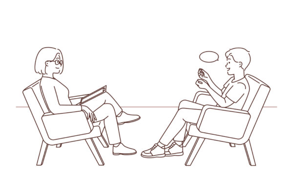 Psychoterapeuta i pacjent siedzą na przeciwko siebie. Pacjent - mężczyzna, opowiada historię, a terapeutka słucha jego wypowiedzi z zainteresowaniem.