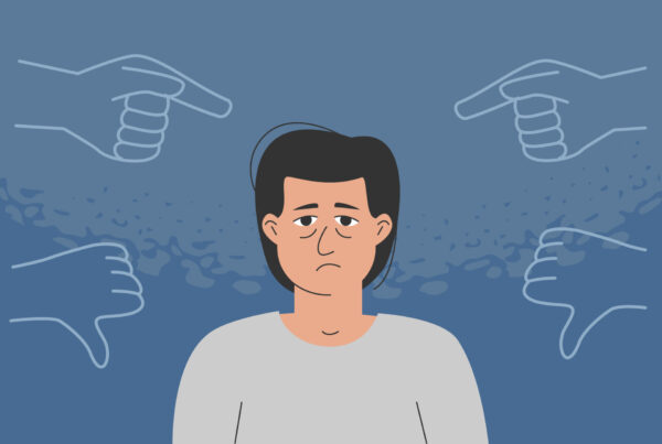 Smutny mężczyzna słucha negatywnej oceny wewnętrznego krytyka.