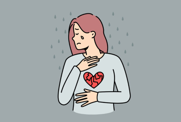 Smutna, płacząca kobieta, trzyma się za klatkę piersiową i brzuch, które fizycznie bolą z powodu żałoby.