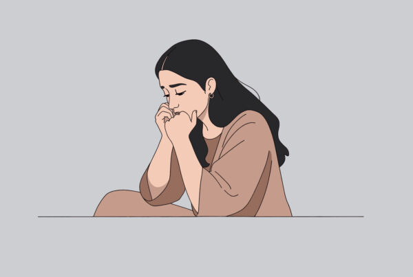 Kobieta siedzi na podłodze z rękoma na twarzy, próbując odtworzyć wspomnienia z dzieciństwa.